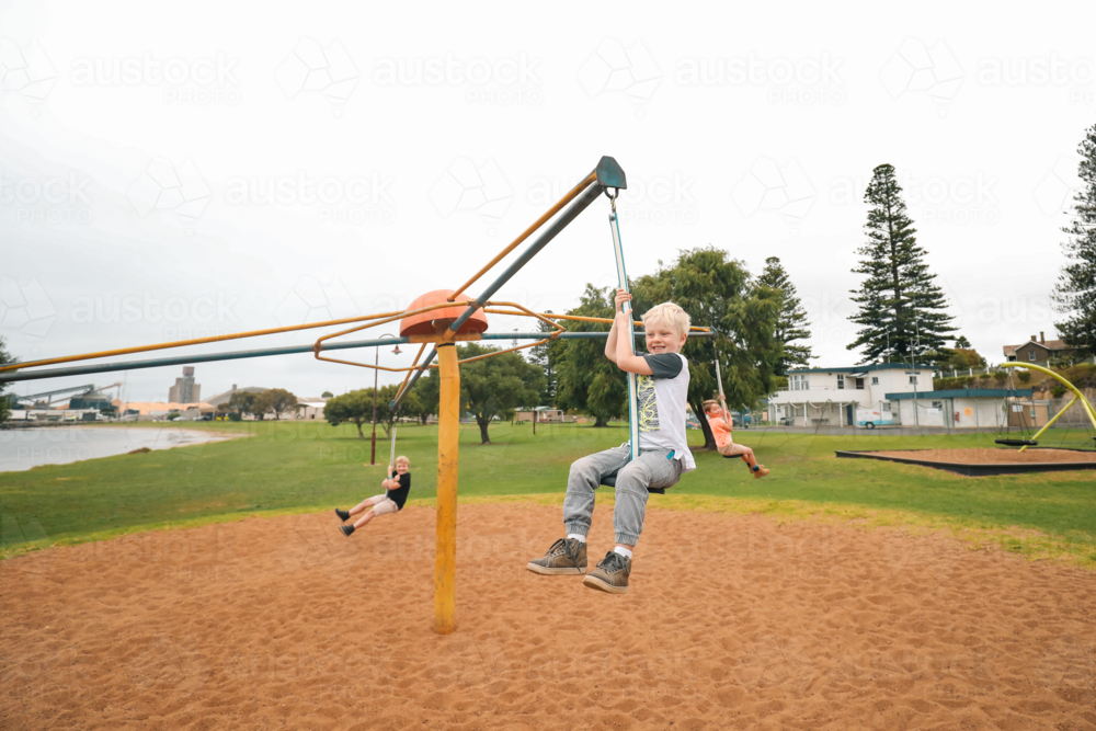 Image of Group of children riding four person swing on the Portland ...