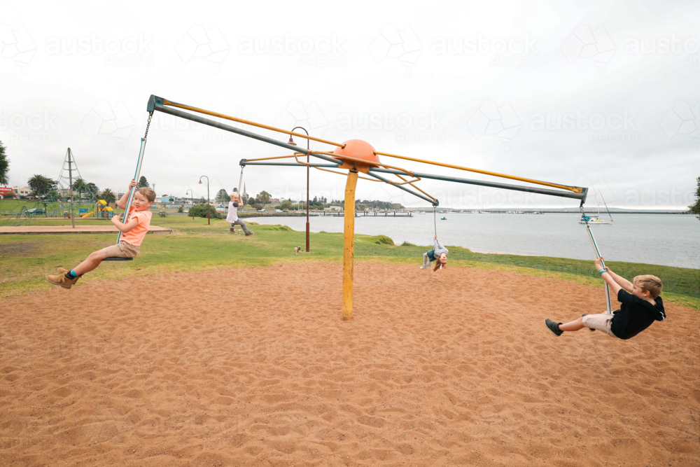 Image of Group of children riding four person swing on the Portland ...