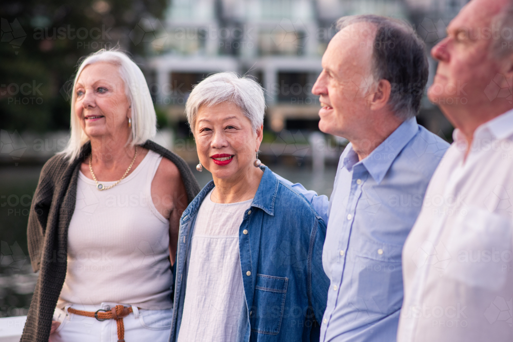 group of happy seniors walking in a coastal setting - Australian Stock Image