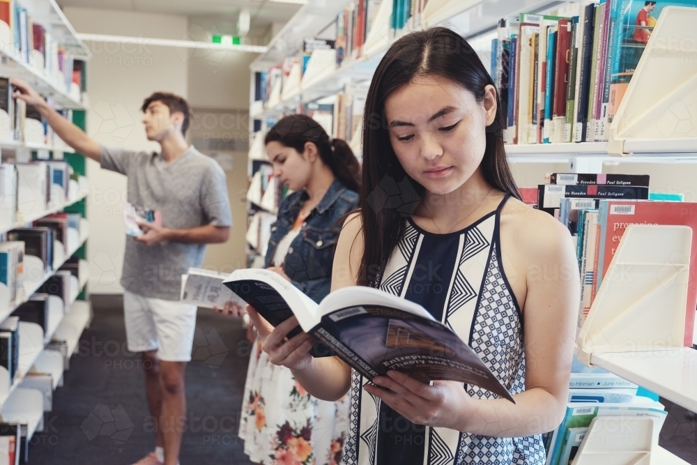 Group of international students reading in university library - Australian Stock Image