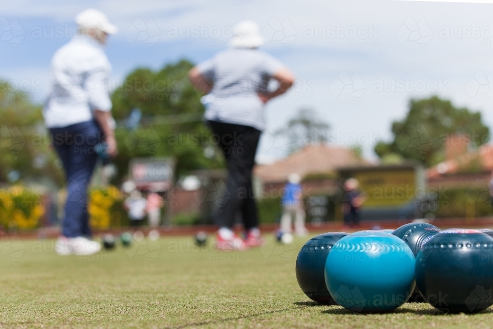 Group of lawn bowls with women in background - Australian Stock Image