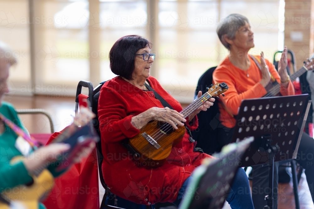 Image of group of old ladies playing ukulele Austockphoto