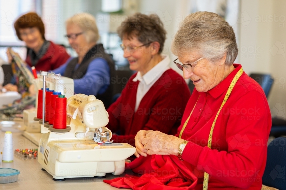 group of older ladies sewing with machines - Australian Stock Image