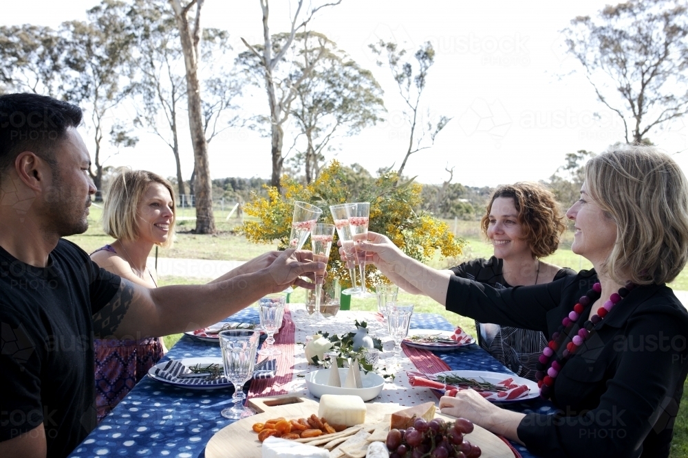 Group of people sitting at a table outside on Christmas day - Australian Stock Image