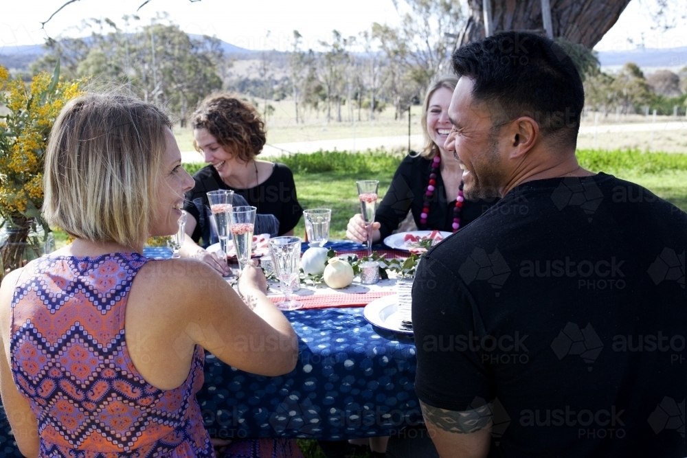 Group of people sitting at a table outside on Christmas day - Australian Stock Image