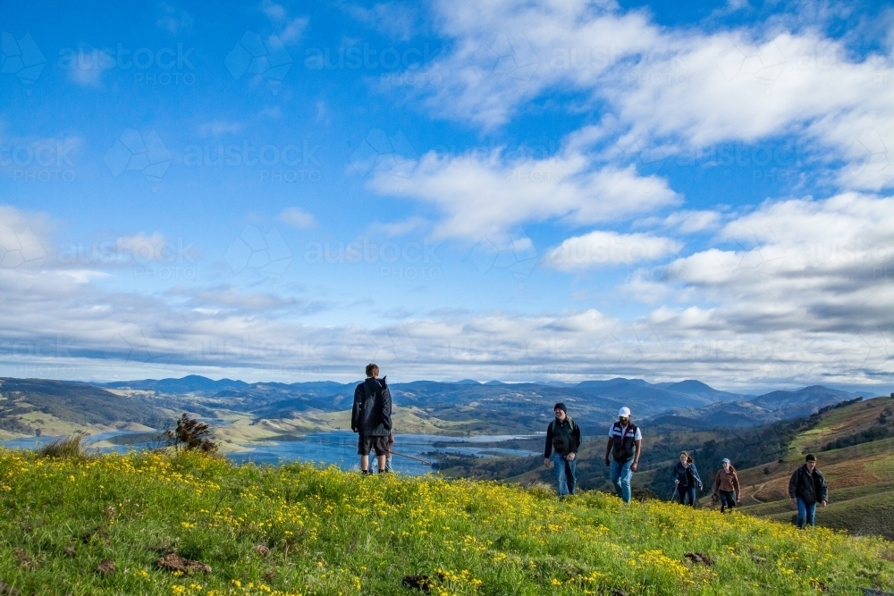 Group of people walking up to the top of a hill - Australian Stock Image