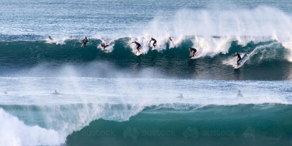 Group of surfers on a wave - Australian Stock Image