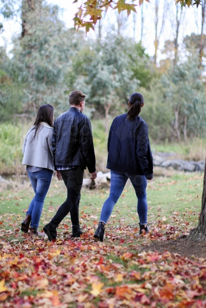 Group of young people walking in a rural environment in autumn - Australian Stock Image