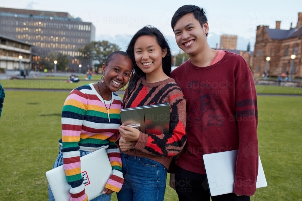 Group of young university students laughing and hanging out on-campus - Australian Stock Image