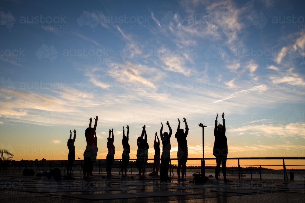 Group yoga at sunrise - Australian Stock Image