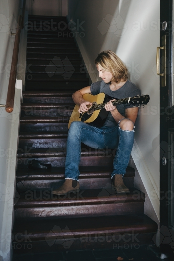 Guitar player learning the lyrics to a new song - Australian Stock Image