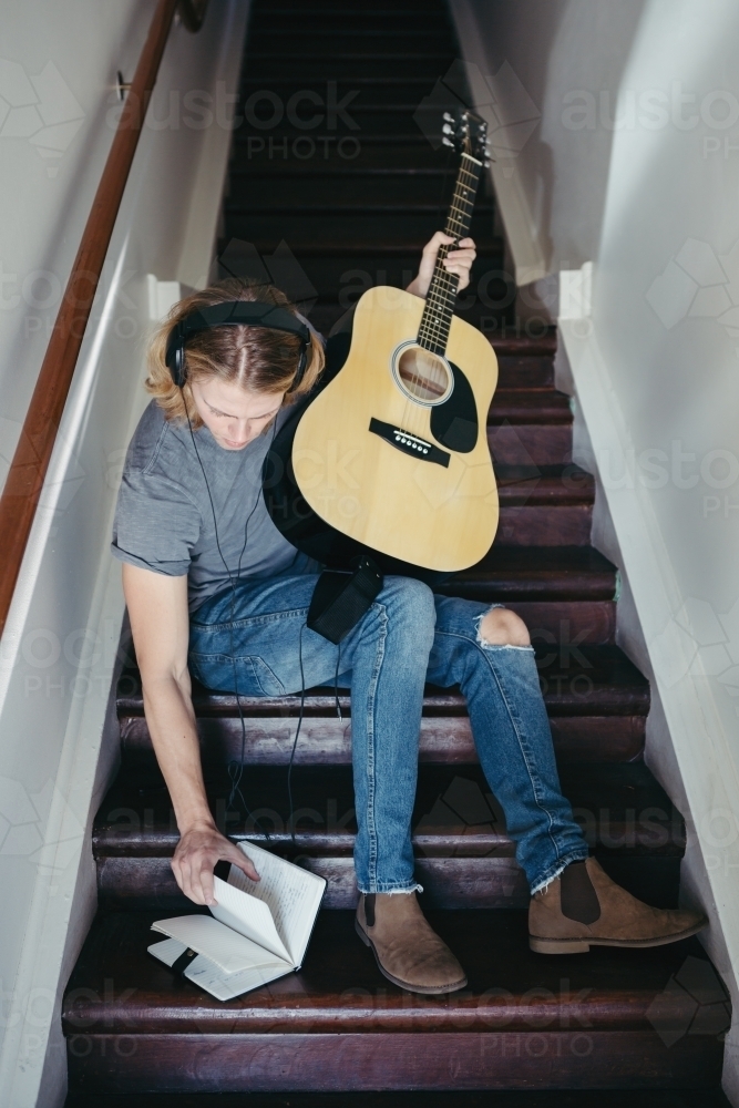 Guitar player learning the lyrics to a new song - Australian Stock Image
