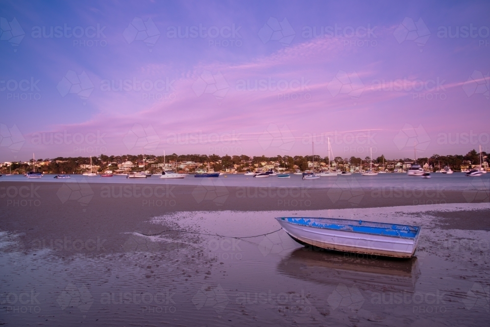 Gunnamatta Bay at low tide at sunrise with small boat - Australian Stock Image