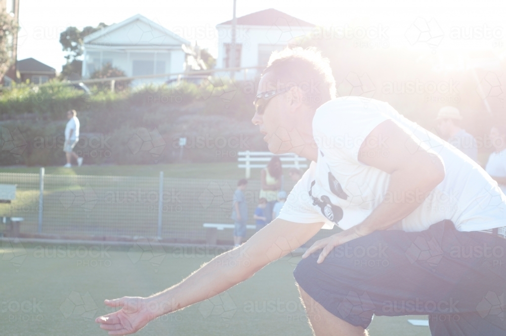 Guy playing lawn bowling in the sun - Australian Stock Image
