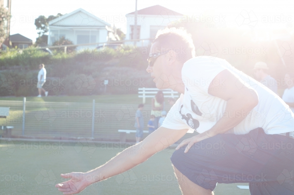 Guy playing lawn bowling in the sun - Australian Stock Image