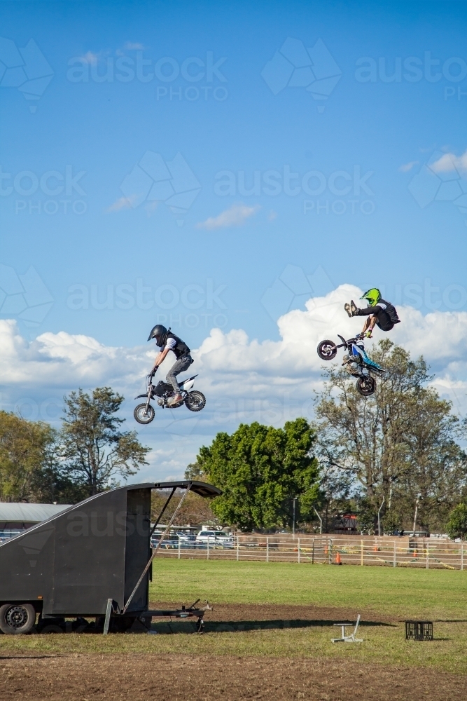 Guys on small motorbikes doing stunts - Australian Stock Image