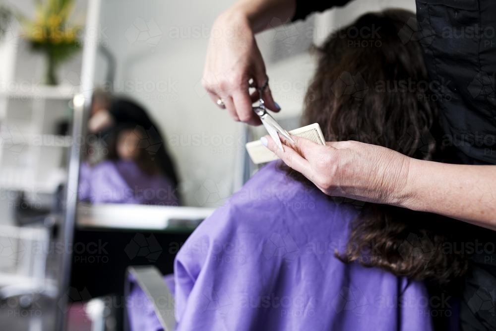 Hairdresser cutting a young girl's hair - Australian Stock Image