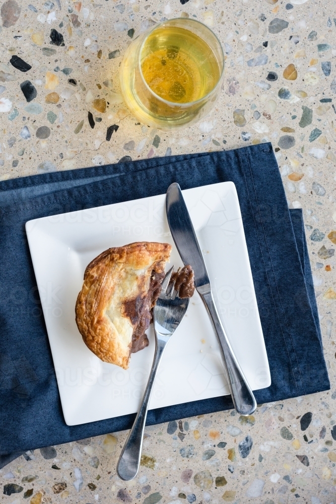 halfway through a meat pie, and beer - Australian Stock Image