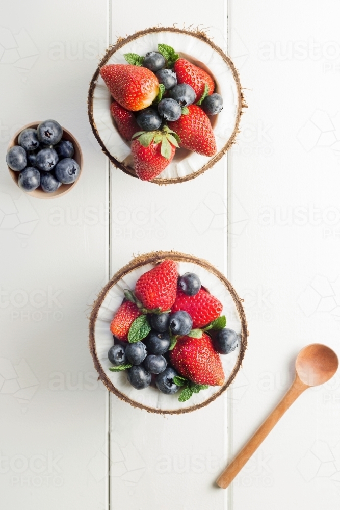 Halved coconuts filled with berries - Australian Stock Image