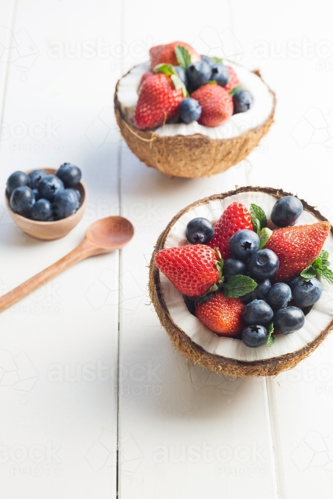 Halved coconuts filled with berries - Australian Stock Image