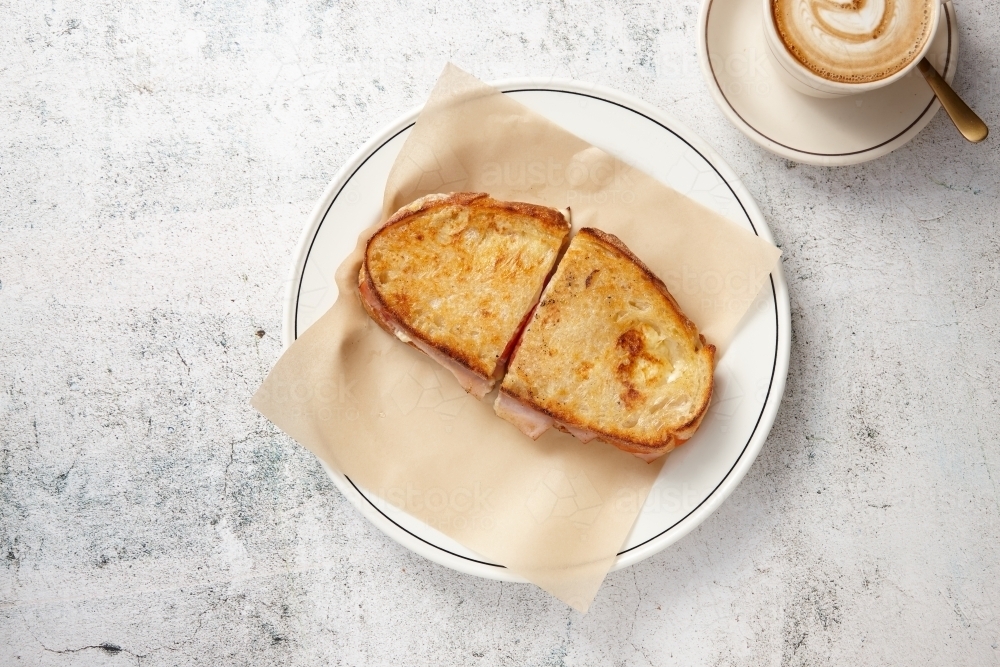 Ham and cheese toasty with coffee on table - Australian Stock Image