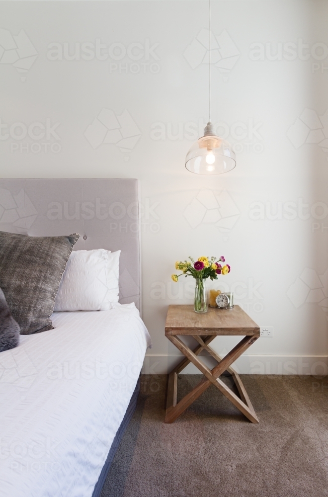Hamptons styled bedside table with hanging pendant light in luxury home - Australian Stock Image