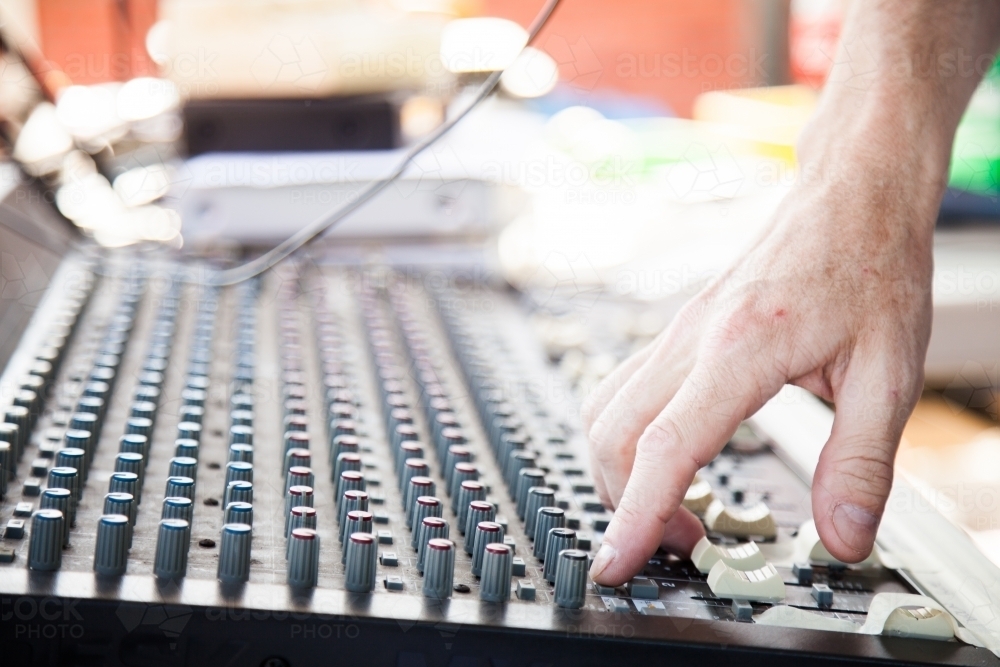 Image of Hand adjusting knobs on a sound system audio mixer - Austockphoto