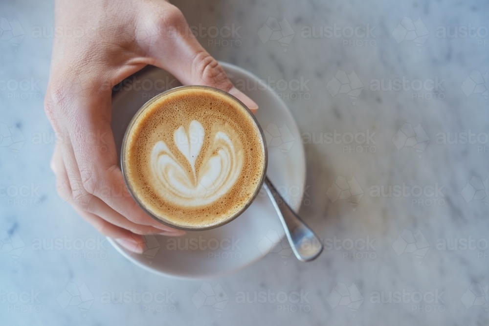 Hand holding a glass of coffee latte : Austockphoto Hand holding a glass of coffee latte - Australian Stock Image