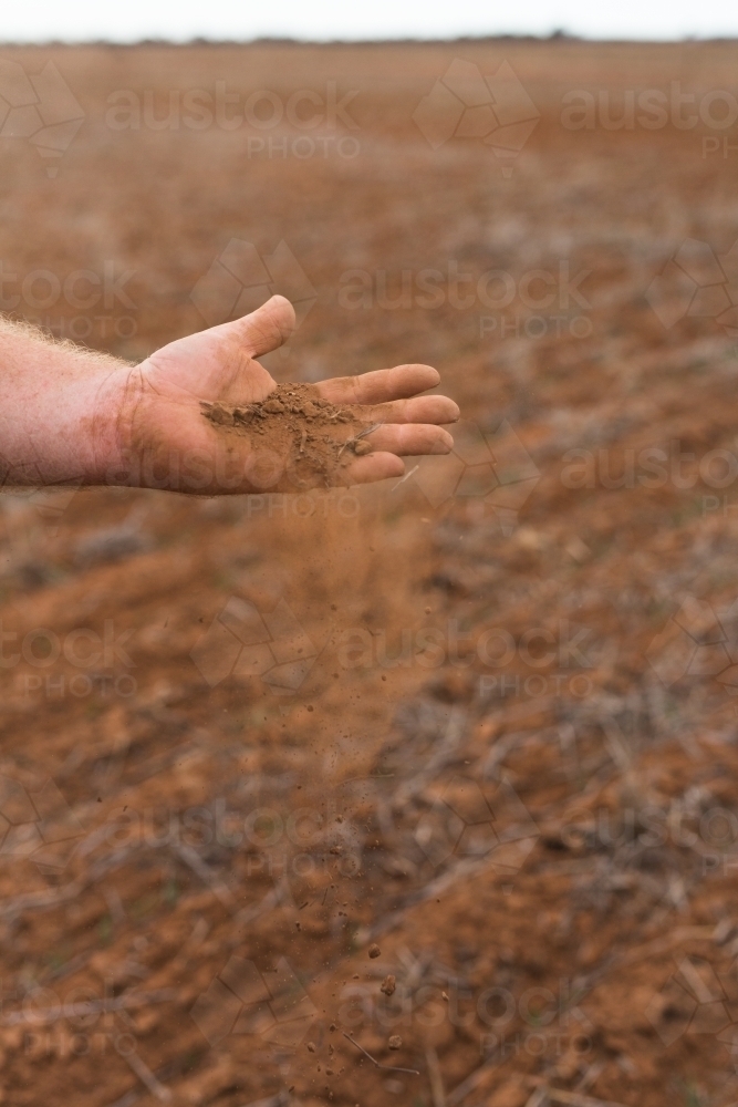 hand holding red earth - Australian Stock Image