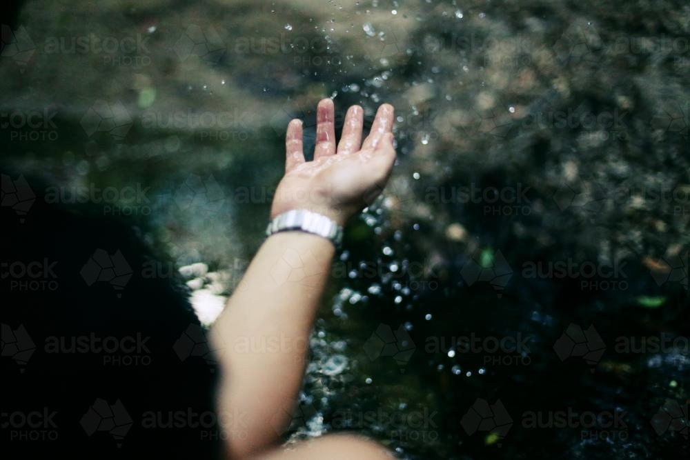 Hand playing with water - Australian Stock Image