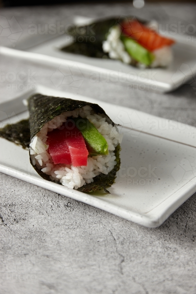Hand rolled sushi served in a square white plate - Australian Stock Image