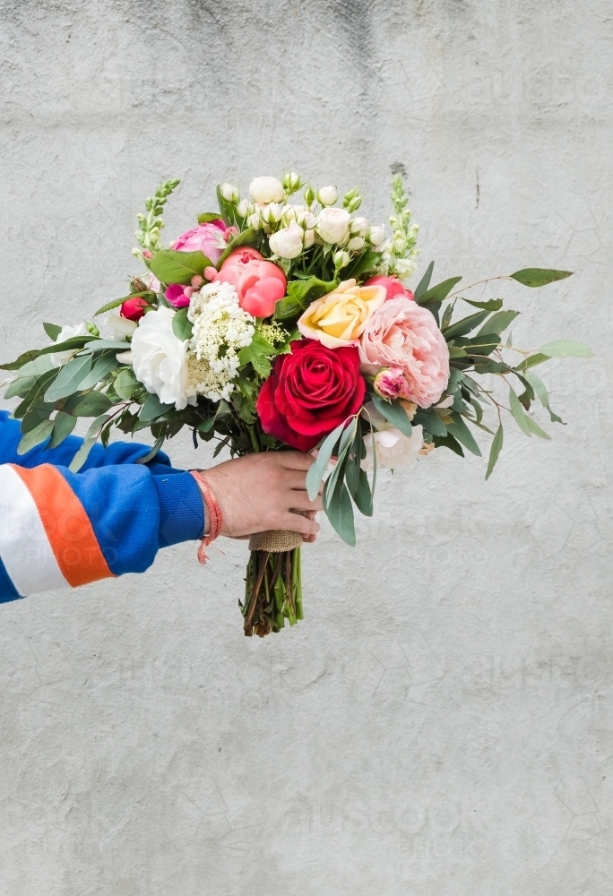 Image of hands holding a bouquet of flowers. - Austockphoto