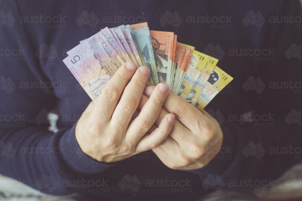 Hands holding a selection of Australian currency notes - Australian Stock Image