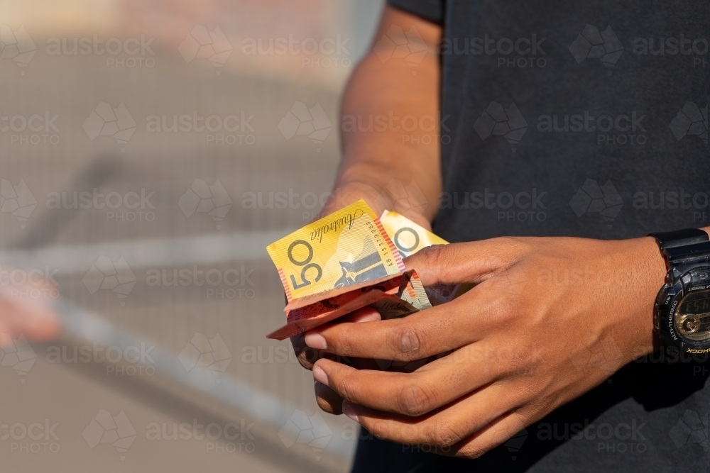 hands holding a variety of polymer notes as cash - Australian Stock Image