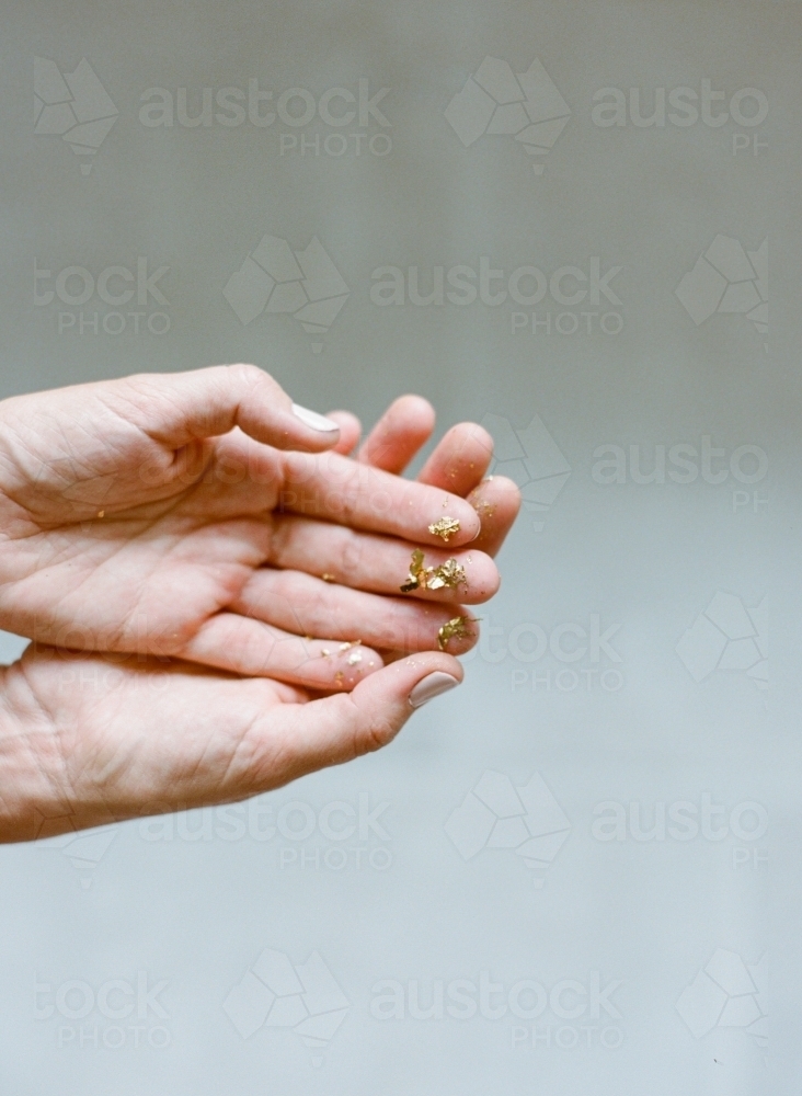 Hands holding little gold specks - Australian Stock Image