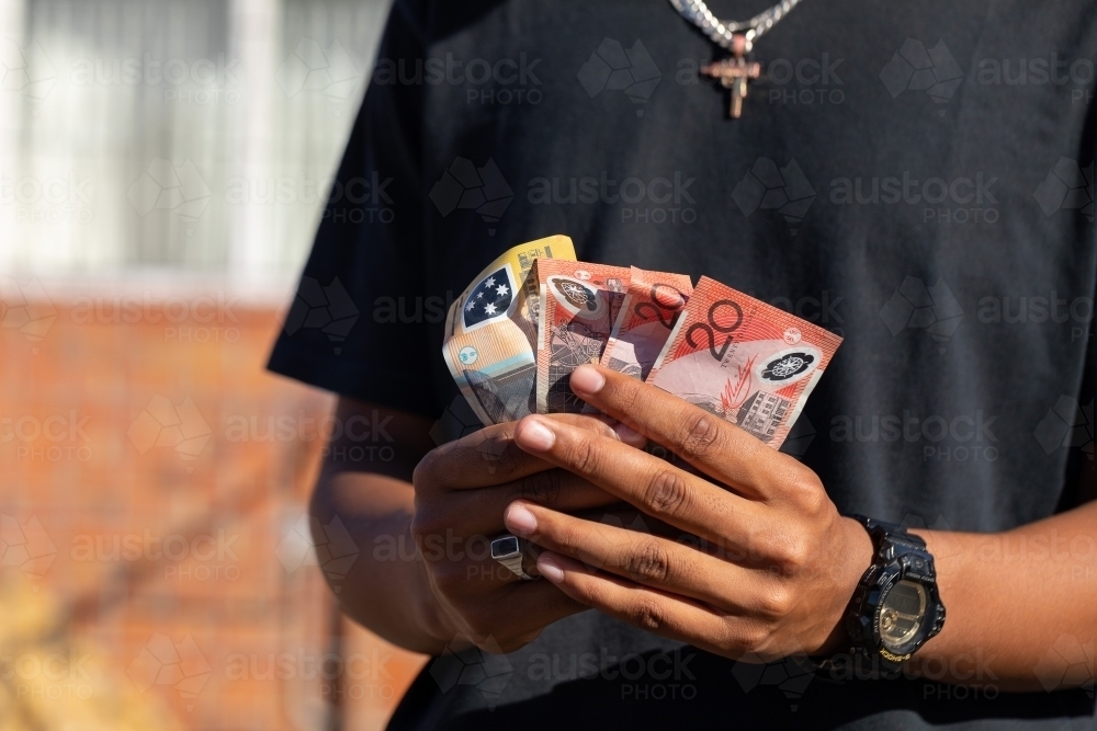 hands holding several banknotes - Australian Stock Image