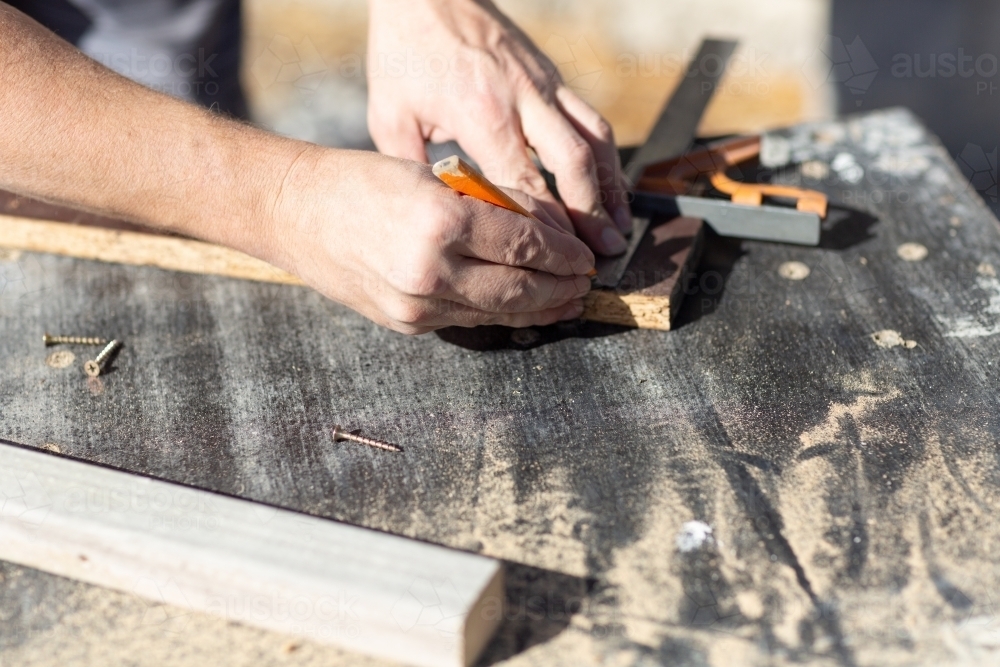 Hands of man measuring DIY project - Australian Stock Image