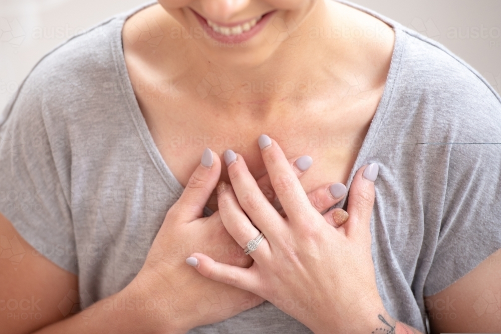 hands on heart meditation pose woman smiling relaxed - Australian Stock Image