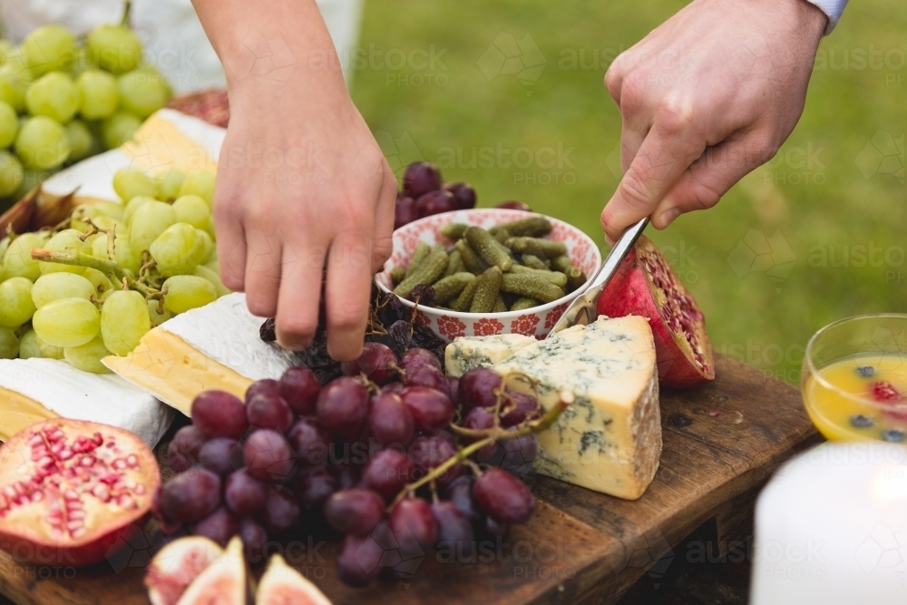 Hands picking food off antipasto platter - Australian Stock Image