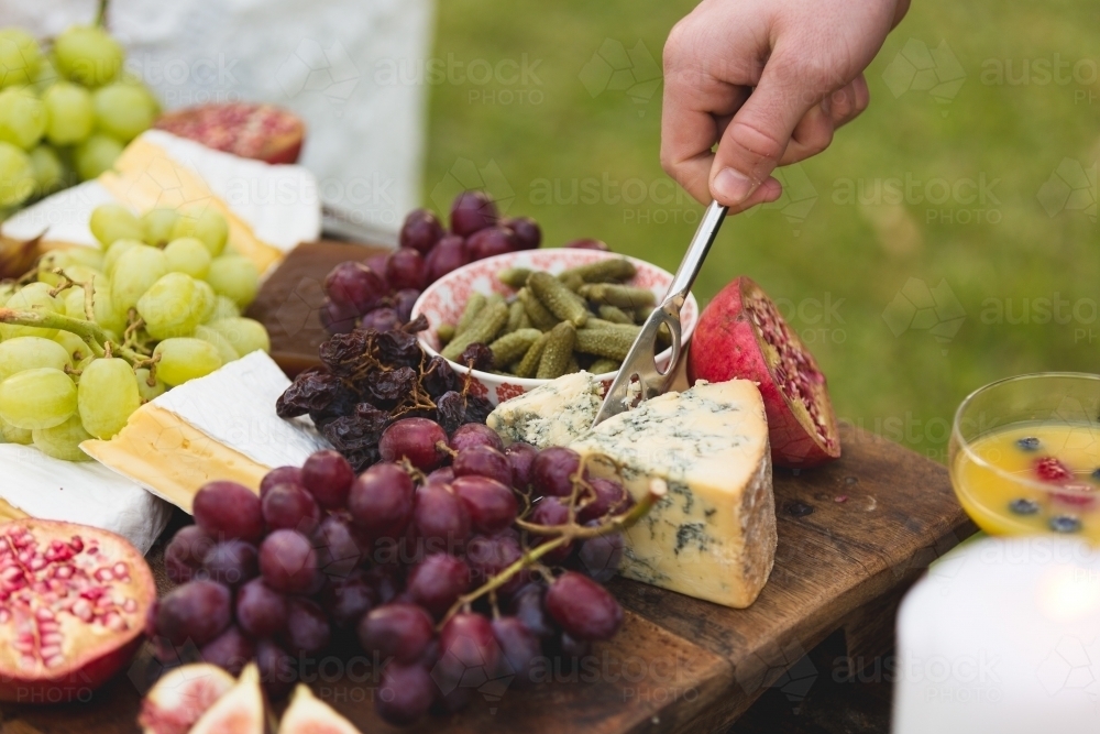 Hands picking food off antipasto platter - Australian Stock Image