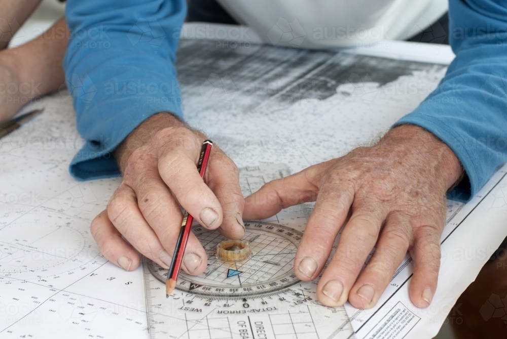 Hands with pencil marking sailing navigation points - Australian Stock Image