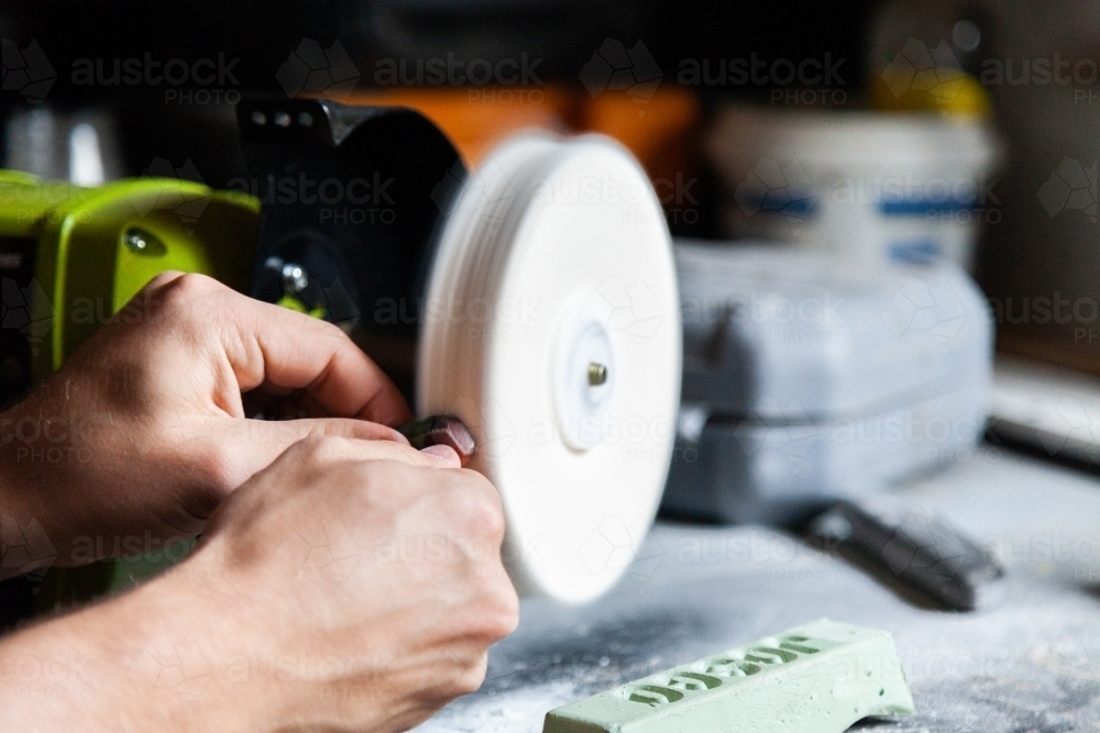 Hands working bench polishing machine - Australian Stock Image
