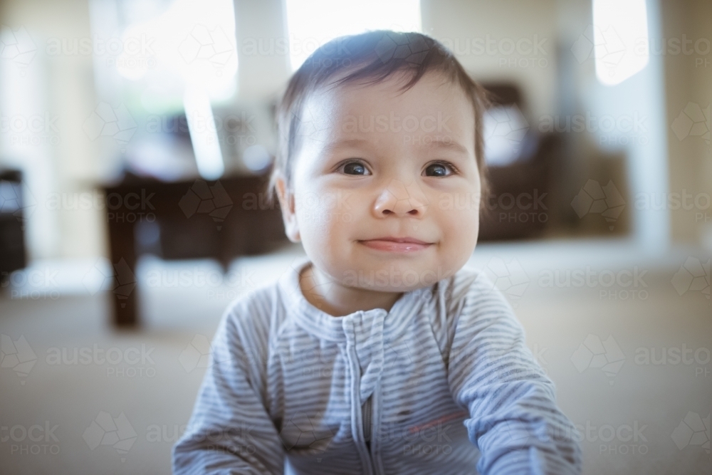 Happy 1 year old mixed race boy plays at home - Australian Stock Image