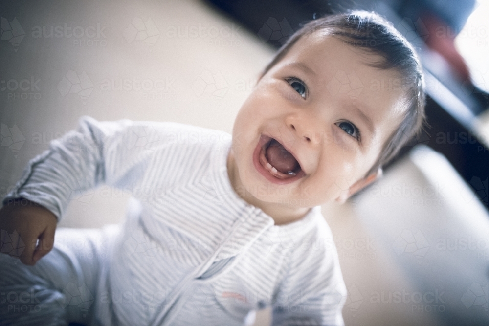 Happy 1 year old mixed race boy plays at home - Australian Stock Image