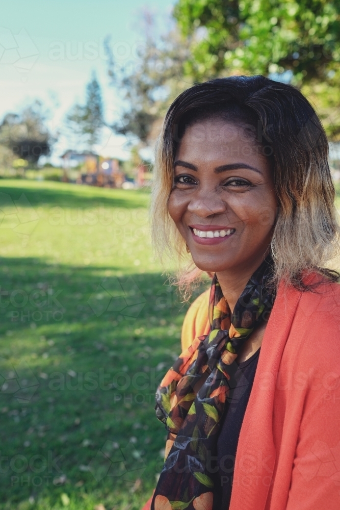 Happy African woman in the park - Australian Stock Image
