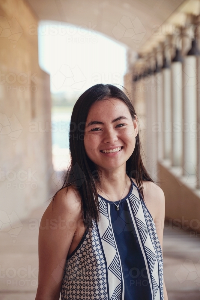 Happy Asian female young adult student in university - Australian Stock Image