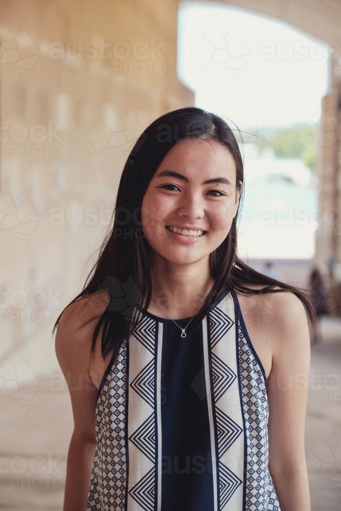 Happy Asian female young adult student in university - Australian Stock Image