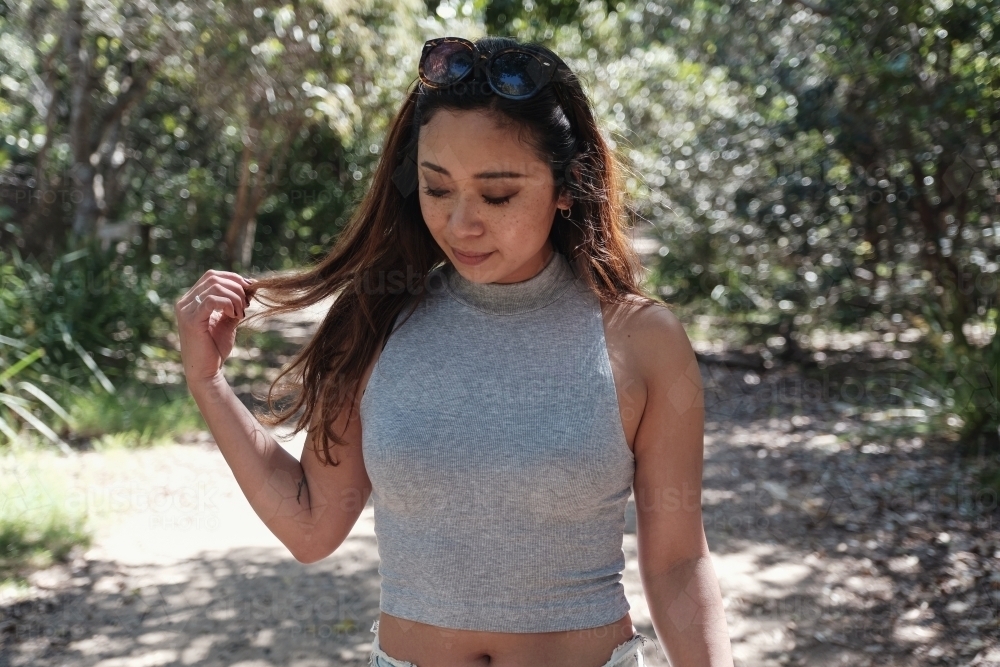 Happy Asian young adult woman in the park - Australian Stock Image