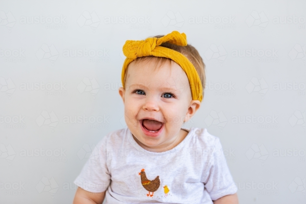 happy aussie baby girl smiling big smile on white copy space background - Australian Stock Image