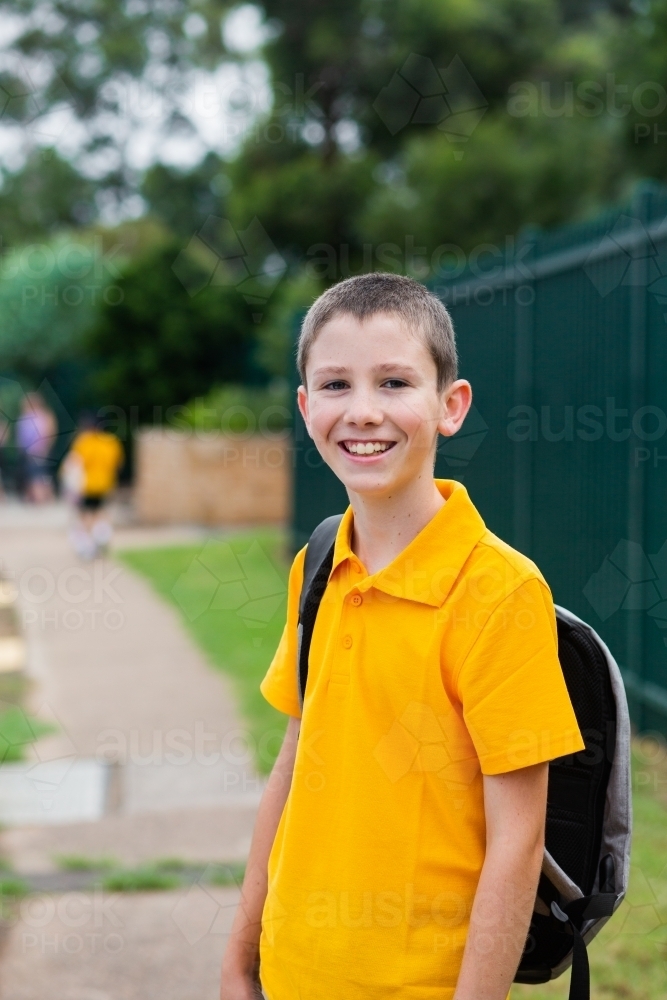 Happy Aussie public school boy with bag ready to go back to school - Australian Stock Image
